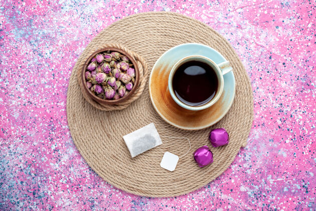 食物顶视图：一杯粉红色背景的带糖果的茶杯子邦邦糖果