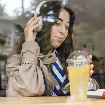 提神咖啡馆里戴着新鲜柠檬水和耳机的女人画像天然食品异国情调