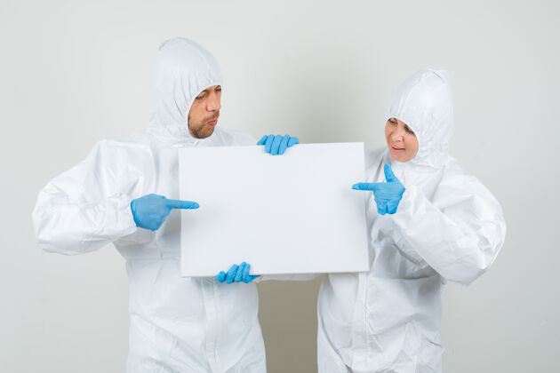 医学两个穿着防护服指着空白帆布的医生专业外科男性