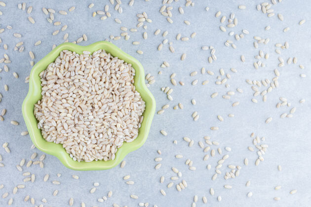 营养短粒米饭散落在大理石背景上 盛在一个绿色的碗里散粮食农业