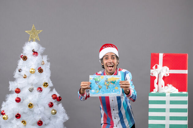 盒子前视图笑脸男子与螺旋弹簧圣诞帽显示世界地图灰色旅行春天