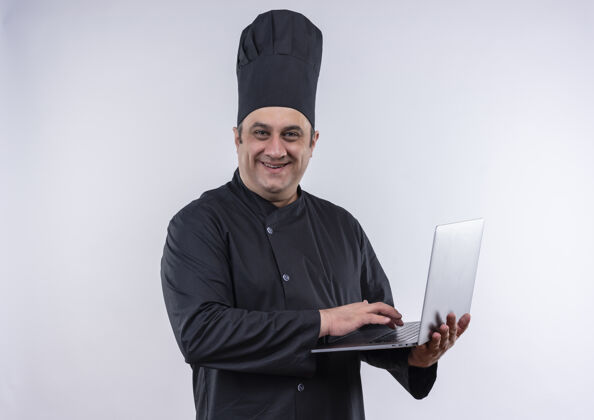 厨师一位身着厨师制服 面带微笑的中年男厨师手里拿着笔记本电脑厨师笔记本电脑男性