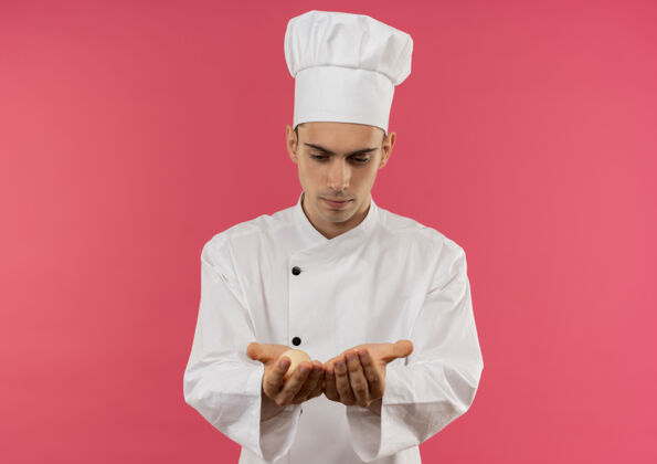 厨师想着年轻的男厨师穿着厨师制服看着鸡蛋在他手里的复制空间男思想制服