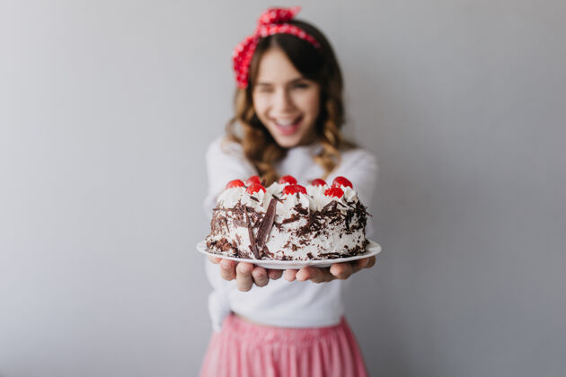休闲美丽女人的肖像 前景是奶油蛋糕幽默的生日女孩孤立微笑配饰美丽