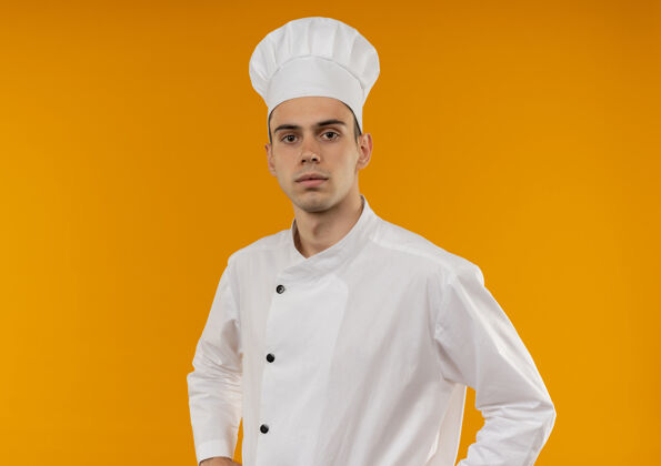 厨师自信的年轻男性酷穿厨师制服-在孤立的黄色墙壁与复制空间外表穿着年轻
