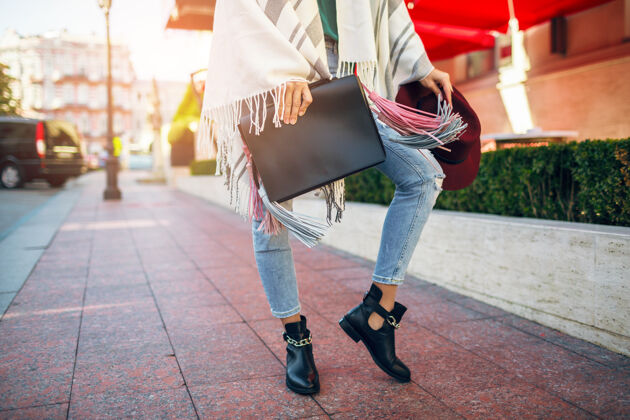 包特写的女人腿穿黑色皮靴 牛仔裤 鞋春季潮流 手袋时尚城市服装