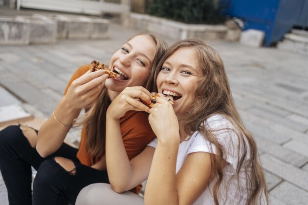 娱乐高角度的年轻女子一起吃比萨饼当地假日美丽积极