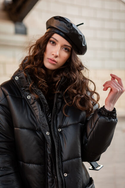 夹克时尚女人摆出冬秋时尚潮流黑色羽绒服和皮帽贝雷帽在美丽老街女人服装街头