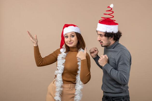 人圣诞节心情与兴奋酷可爱的情侣戴着红色圣诞老人帽子指着上面成人穿着情侣