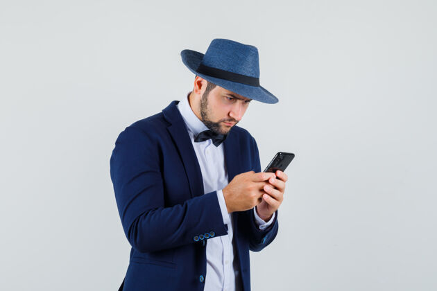 忙碌年轻人穿着西装 戴着帽子在手机上打字 看上去很忙手机帽子人