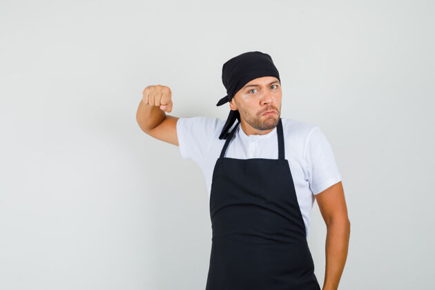 问候语面包师用拳头威胁着穿t恤 围裙的人 看上去很愤怒食物挥手美味