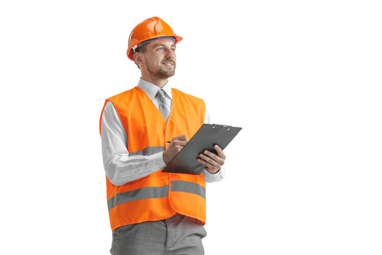 保护穿着建筑背心和橙色头盔的建筑工人站在白色的工作室里专家建筑帅哥