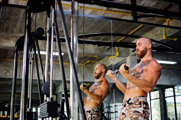 运动纹身的健康男人在健身房锻炼休闲肌肉运动