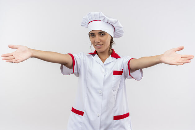 厨师面带微笑的年轻女厨师身穿厨师制服 向镜头伸出双手制服拿着女