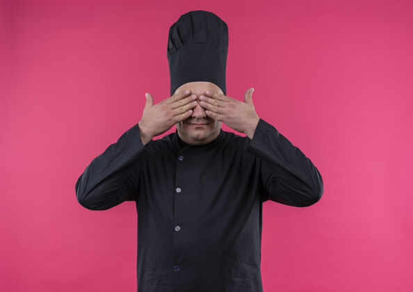 中年高兴的中年男厨师身着厨师制服 双手捂着眼睛 孤零零地站在粉红色的墙上厨师厨师封面