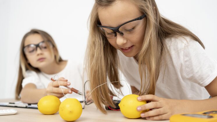 学习两个女孩用电和柠檬做科学实验学习眼镜实验