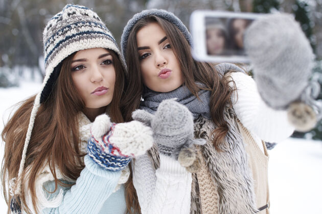 亲吻最好的朋友在冬天自拍衣服享受冷冻