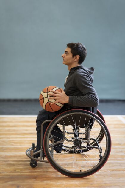 生活方式拿着篮球的年轻残疾人残疾坐姿垂直
