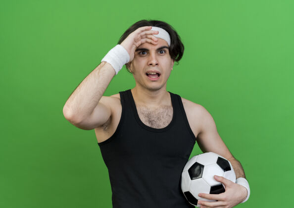 球穿着运动服 头戴足球带的年轻运动型男子 被人搞糊涂了困惑看绿色