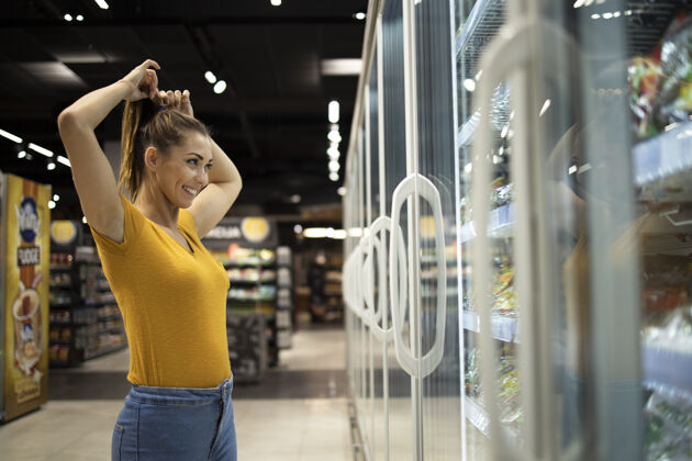 满意超市里的女人在冰箱里挑选食物模型冰箱有机