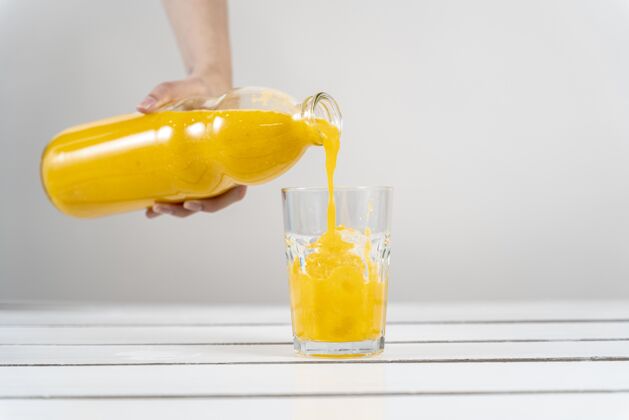 天然特写手倒橙汁在玻璃水平分类饮料