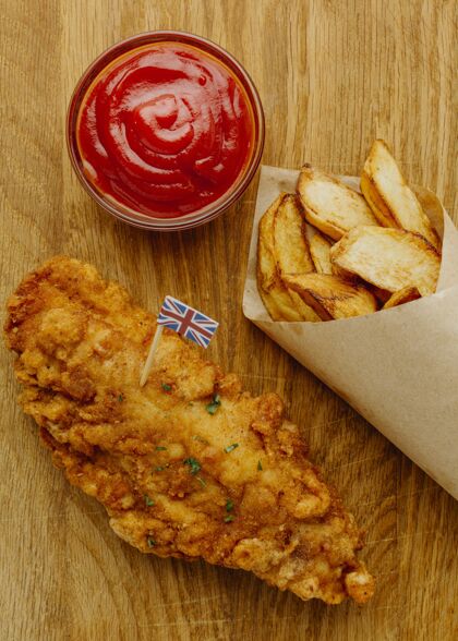 英国用番茄酱纸包装的鱼和薯条的俯视图国旗伟大的英国菜
