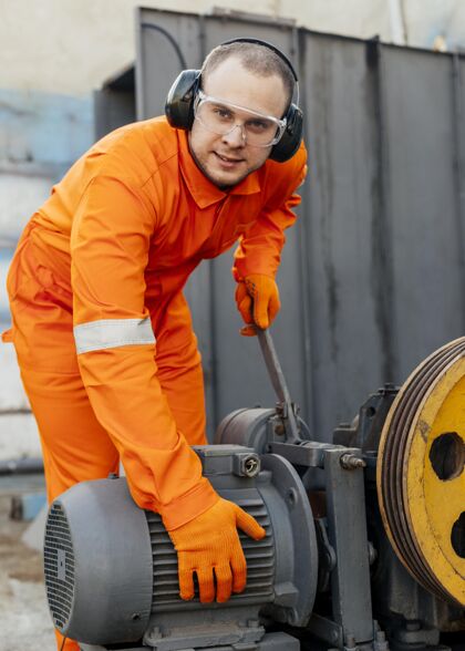 工作戴着耳机和防护眼镜的工人的前视图男性工人职业