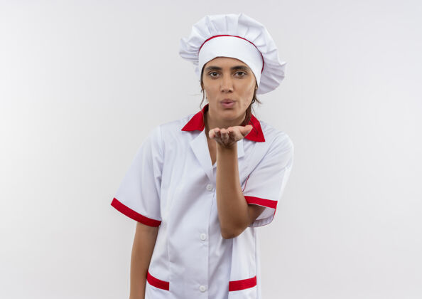 手势身穿厨师制服的年轻女厨师在隔离的白色墙壁上展示亲吻手势 并留有复制空间厨师年轻厨师
