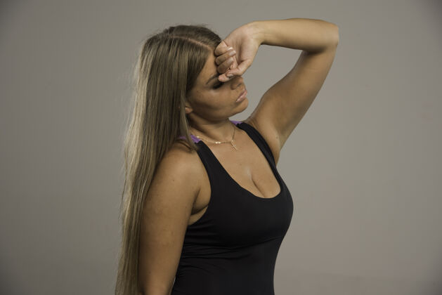 成人穿着运动胸罩的女模特把手放在额头上 看起来很累 侧视图健身人运动